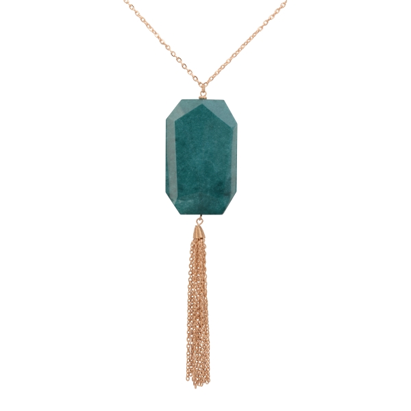 Gold tone necklace featuring a large teal natural stone with a metal tassel. Approximately 30" in length. 