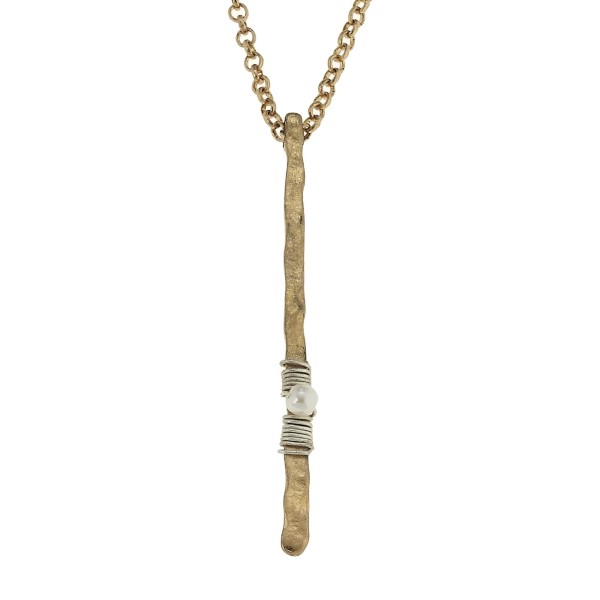 Dainty worn gold tone necklace featuring a wire wrapped bar pendant with a pearl bead accent. Approximately 28" in length.