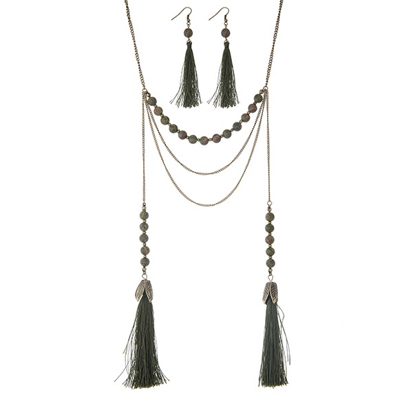 Burnished gold tone layering necklace set displaying green and brown beads with two 3 1/2" fabric tassels. Approximately 28" in length.