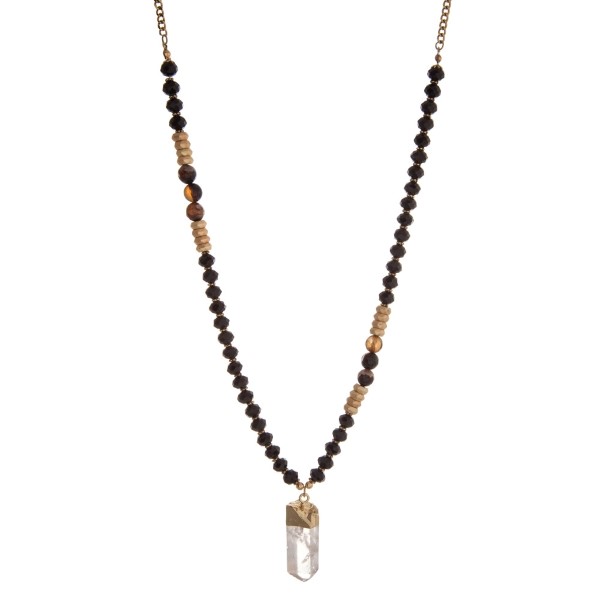 Gold tone necklace with black beads and a crystal pendant. Approximately 32" in length. 
