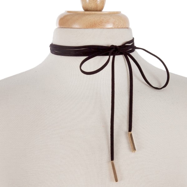 Black faux suede wrap necklace with gold tone hardware. Approximately 84" in length. 