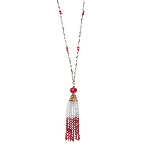 Gold tone necklace with a crimson and white beaded tassel pendant. Approximately 32" in length.