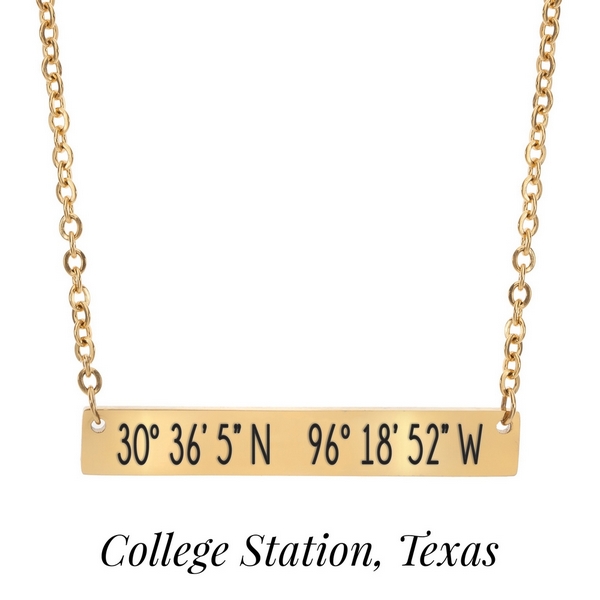 Gold tone necklace with a bar pendant stamped with the coordinates of College Station, Texas. Approximately 18" in length. 