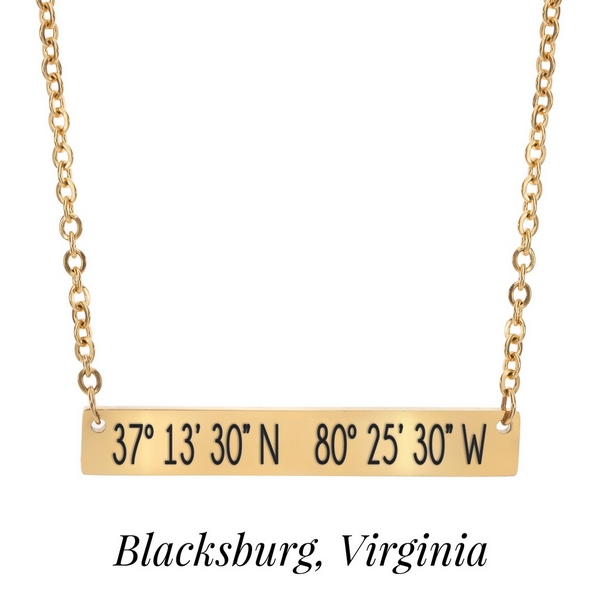 Gold tone necklace with a bar pendant stamped with the coordinates of Blacksburg, Virginia. Approximately 18" in length. 