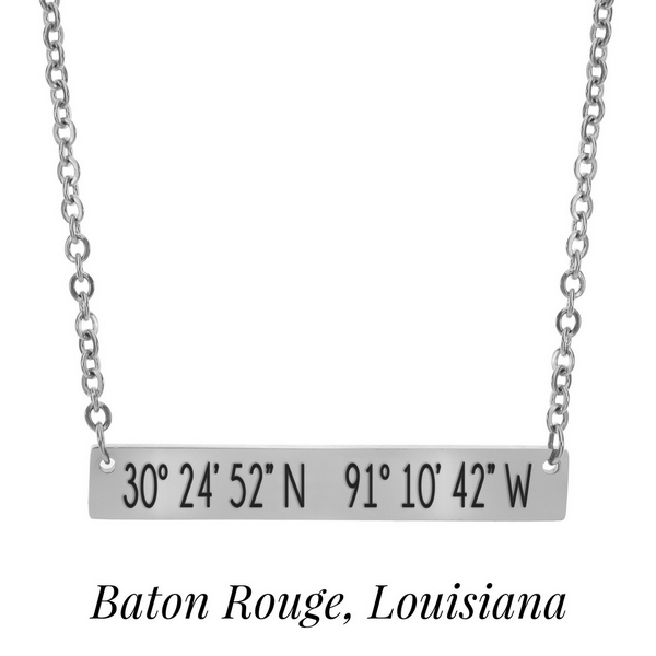 Silver tone necklace with a bar pendant stamped with the coordinates of Baton Rouge, Louisiana. Approximately 18" in length. 