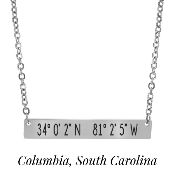 Silver tone necklace with a bar pendant stamped with the coordinates of Columbia, South Carolina. Approximately 18" in length. 