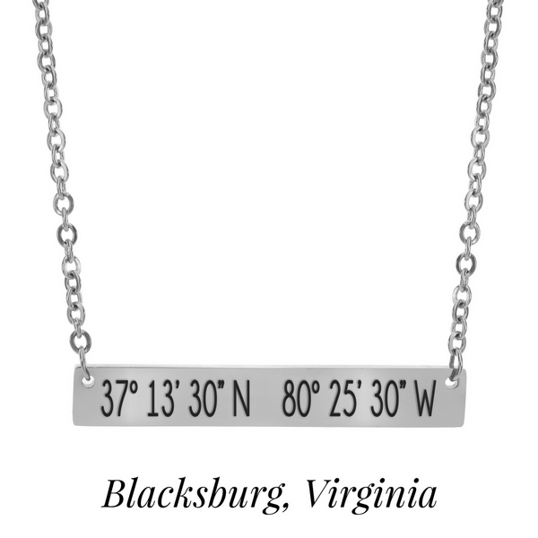 Silver tone necklace with a bar pendant stamped with the coordinates of Blacksburg, Virginia. Approximately 18" in length. 