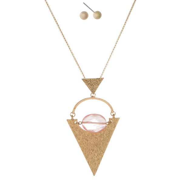 Gold tone necklace with a hammered gold tone triangle pendant and faceted peach bead. Approximately 32" in length. 