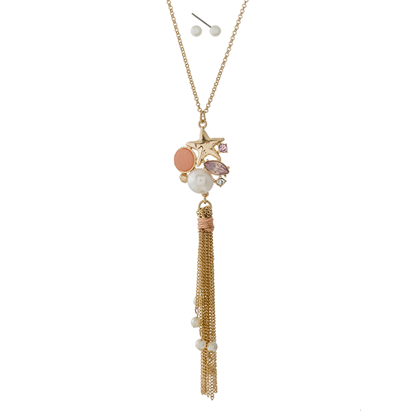 Gold tone necklace set with a seashell, peach rhinestone, and tassel pendant. Approximately 22" in length. 