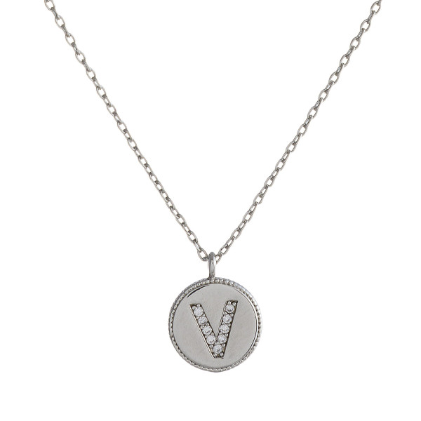 Dainty silver cable chain necklace featuring a disc pendant with "V" initial and cubic zirconia details. Pendant approximately 1cm in diameter. Approximately 16" in length overall.