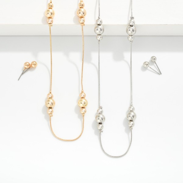 Snake Chain Necklace Featuring Metal Tone Bead Cluster Stations 
- Metal Tone Ball Studs Included 
- Approximately 16" L
- Extender 3" L