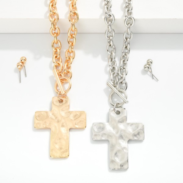 Metal Tone Chain Link Necklace Featuring Gold Tone Hammered Cross Pendent & Toggle Clasp 

- Approximately 20" L
- Metal Tone Stud Earrings Included
