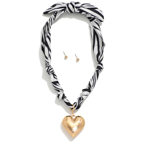 Zebra Bandana Necklace Featuring Gold Tone Heart Pendent & Toggle Clasp 

- Approximately 20" L
- Metal Tone Stud Earrings Included
