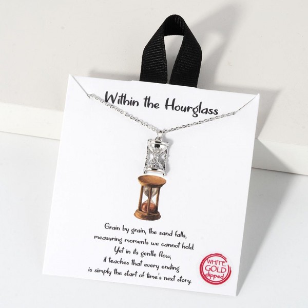 Dainty Chain Link Necklace Featuring Cubic Zirconia Hourglass				
					
- Approximately 16" L					
- Extender 2" L					
- Hypoallergenic Brass Base					
- 18K Gold Dipped					
- Card: "Grain by grain, the sand falls, measuring moments we cannot hold. Yet in its gentle flow, it teaches that every ending is simply the start of time's next story."					