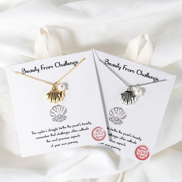 Dainty Chain Link Necklace Featuring Metal Tone Shell & Pearl Pendant 					
						
- Approximately 16" L						
- Extender 2" L						
- Hypoallergenic Brass Base						
- 18K Gold Dipped						
- Card: "The oyster's struggle births the pearl's beauty; remember that challenges often cultivate the most precious aspects of your own journey."						