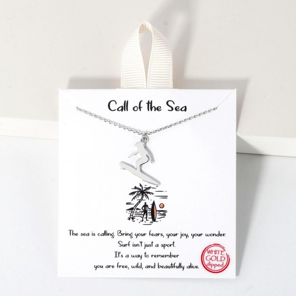 Dainty Chain Link Necklace Featuring Metal Tone Surfer Pendant					
					
- Approximately 16" L					
- Extender 2" L					
- Hypoallergenic Brass Base					
- 18K Gold Dipped					
- Card: " The sea is calling. Bring your fears, your joy, your wonder: Surf isn't just a sport. It's a way to remember you are free, wild, and beautifully alive."					