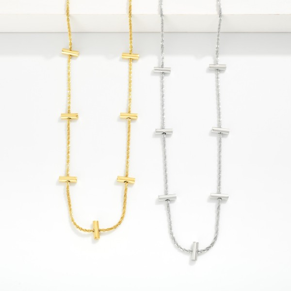 Twisted Chain Link Necklace Featuring Metal Tone Bar Stations 

- Stainless Steel
- Water Resistant
- Approximately 16" L
- Extender 2" L