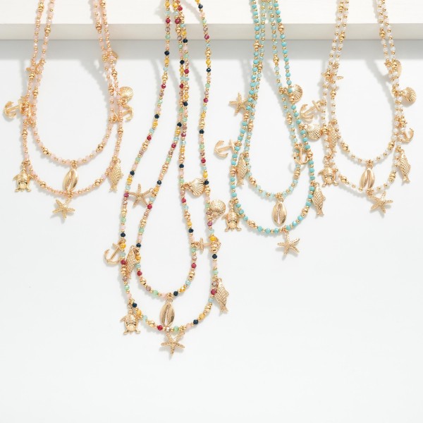 Layered Beaded Necklace Featuring Metal Beach Charms, Faceted Bead & Gold Tones 

- Approximately 18" L 
- Extender 3" L 