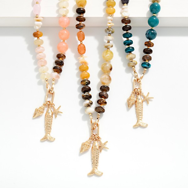 Marbled Acetate & Stone Beaded Necklace Featuring Metal Tone Fish & Shell Pendant 

- Approximately 16" L
- Extender 3" L