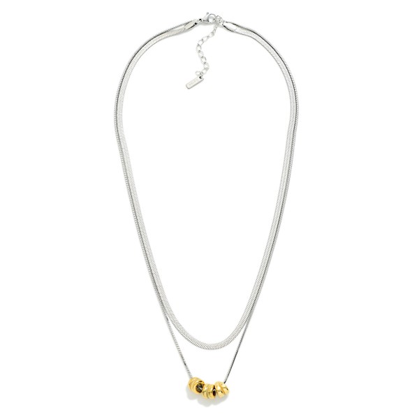 Layered Herringbone Chain Link Necklace Feating Metal Tone Beaded Disks 

- Stainless Steel 
- Approximately 16.5" L
- Extender 2" L 