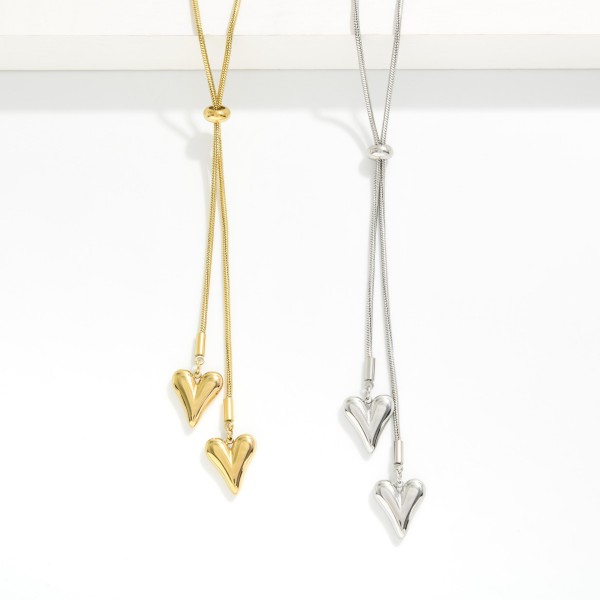 Snake Chain Bolo Style Necklace Featuring Heart Pendents 

- Approximately 22" L 
- Stainless Steal
- Water Resistant
