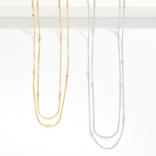 Layered Snake Chain Necklace Featuring Metal Ball Stations 

- Approximately 15" L 
- Extender 3"L 
- Stainless Steel 
- Water Resistant 