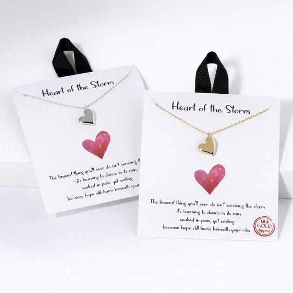 Dainty Chain Link Necklace Featuring Metal Tone Heart Pendant 

- Gold Dipped
- Hypoallergenic Brass Base
- Approximately 16" L
- Extender 2" L
- Made in Korea
- Lead & Nickel Free

Card Reads : "The bravest thing you'll ever do isn't surviving the storm- it's learning to dance in its rain, soaked in pain, yet smiling because hope still hums beneath your ribs."


