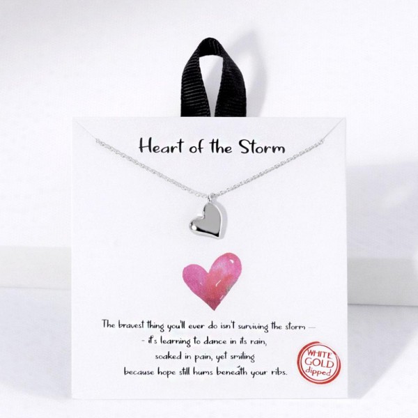 Dainty Chain Link Necklace Featuring Metal Tone Heart Pendant 

- Gold Dipped
- Hypoallergenic Brass Base
- Approximately 16" L
- Extender 2" L
- Made in Korea
- Lead & Nickel Free

Card Reads : "The bravest thing you'll ever do isn't surviving the storm- it's learning to dance in its rain, soaked in pain, yet smiling because hope still hums beneath your ribs."

