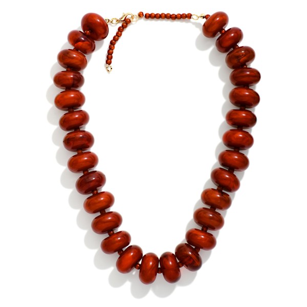Chunky Rondelle Bead Necklace with oversized glossy beads finished by a slim seed bead strand at the back for comfortable wear. The bold, collar length silhouette makes a statement on its own over sweaters, tees, and simple dresses. A secure clasp keeps it in place all day. Statement bead necklaces like this are a fall favorite and an easy add on for customers building a complete look.