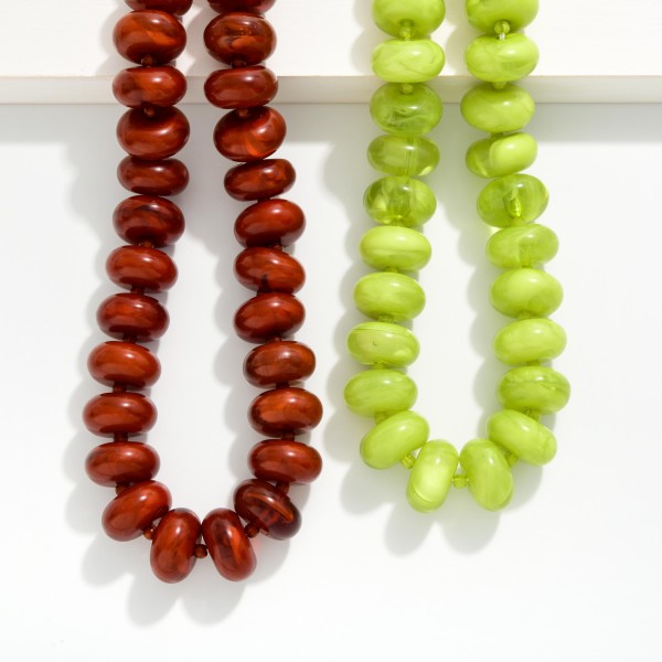 Chunky Rondelle Bead Necklace with oversized glossy beads finished by a slim seed bead strand at the back for comfortable wear. The bold, collar length silhouette makes a statement on its own over sweaters, tees, and simple dresses. A secure clasp keeps it in place all day. Statement bead necklaces like this are a fall favorite and an easy add on for customers building a complete look.