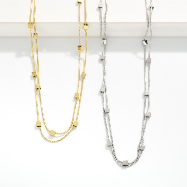 Layered Snake Chain Necklace Featuring Metal Tone Square Stations 

- Stainless Steel 
- Water Resistant 
- Approximately 14" L
- Extender 2" L