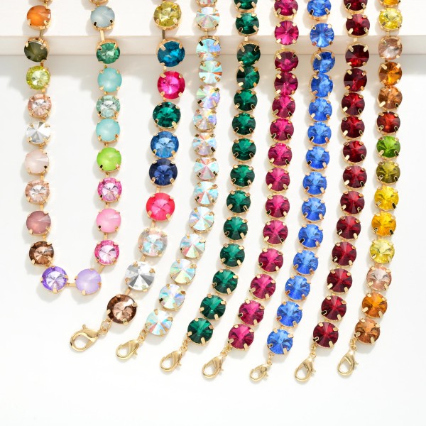 Crystal Cup Chain Necklace lined with large round glass crystals in polished prong settings for bold, glamorous sparkle. The uniform stone design looks elegant on its own and layers beautifully with pendants and fine chains. A lobster clasp and extender chain allow an easy, adjustable fit. Crystal statement necklaces are a holiday essential and sell quickly for events, gifting, and New Year's celebrations.