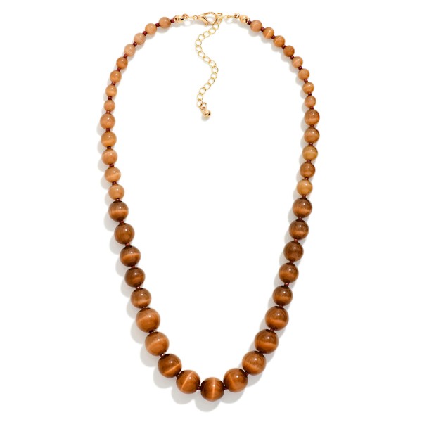 Graduated Bead Necklace with polished round stone look beads that grow in size toward the center for a classic, balanced drape. The glossy beads have a rich, natural shimmer, and the extender keeps the length adjustable. A timeless piece for church, the office, holiday gatherings and gifting. Classic beaded necklaces like this appeal to every age and sell steadily season after season.