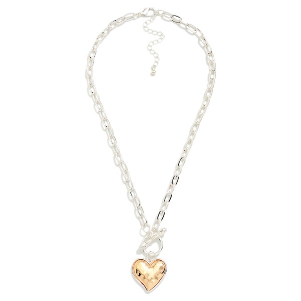 Two Tone Heart Pendant Necklace with a hammered puffy heart in a contrasting metal finish, hung from a front toggle on a polished cable chain. The dimensional heart catches the light from every angle, and the extender makes the length easy to adjust. A sweet pick for Valentine's Day, Galentine's gifts, Mother's Day and everyday wear. Heart styles sell all year, and this mixed metal version goes with everything.
