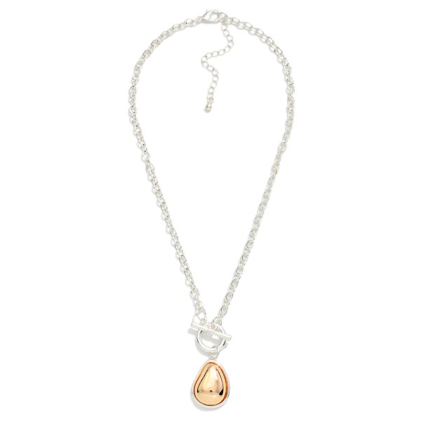 Two Tone Teardrop Pendant Necklace with a polished domed drop framed in a contrasting metal bezel, hung from a front toggle on a textured cable chain. The mixed metal look pairs easily with any jewelry already in her collection, and the extender adjusts the length. A clean everyday piece for workwear, weekends and gifting. Mixed metal styles are a top request, and this one comes in at an easy price.