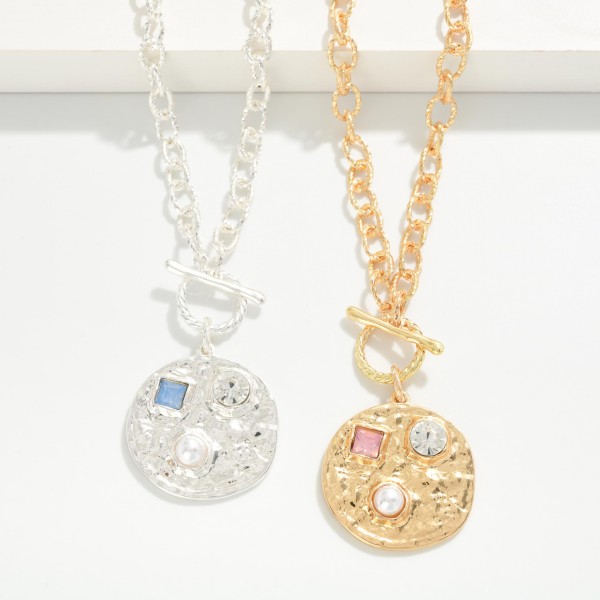 Toggle Medallion Necklace with a hammered coin pendant studded with crystal and stone accents, hung from a front toggle on a textured rolo chain. The organic hammered finish feels artisan and works with everything from denim to dresses, with an extender for easy sizing. A versatile everyday piece for gifting, travel and weekend style. Coin and toggle details are trending, and this one hits both at an easy price point.