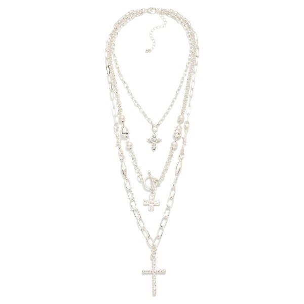 Layered Cross Necklace with three strands: a dainty chain with a rhinestone cross, a beaded chain with a toggle accent and cross charm, and a paperclip chain finished with a pave cross pendant. Already layered for an effortless stacked look that drapes from the collarbone to mid chest, with an extender for easy sizing. A meaningful gift for Christmas, Easter, baptisms, confirmations and Mother's Day. Faith pieces sell steadily year round, and the stacked style makes an easy add on at the counter.