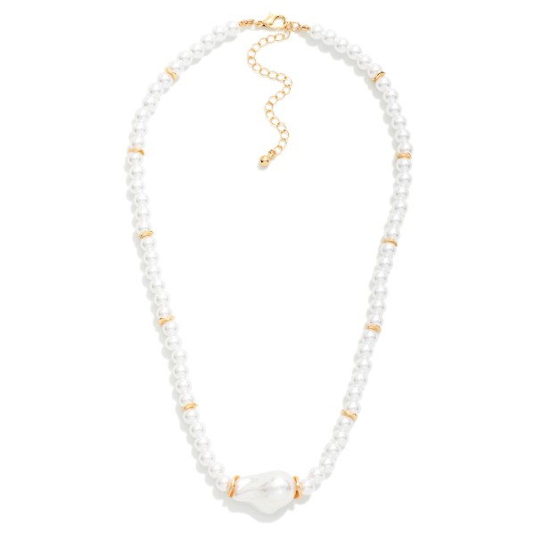 Baroque Pearl Beaded Necklace featuring a strand of faux pearls with polished metal bead accents and an organic baroque pearl centerpiece. The irregular center pearl adds a modern twist to a timeless strand. Finished with a lobster clasp and extender chain. Elegant for weddings, showers, and holiday events yet easy to wear every day, pearls remain a top seller in boutiques.