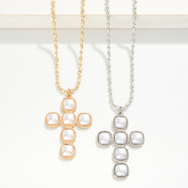 Pearl Cross Pendant Necklace featuring a cross formed from square faux pearl cabochons set in polished bezels, hung on a fine link chain. The soft luster gives a classic faith symbol an elegant, heirloom feel. Finished with a lobster clasp and extender. A beautiful gift for baptisms, first communions, and Christmas, and a standout piece for faith inspired displays.