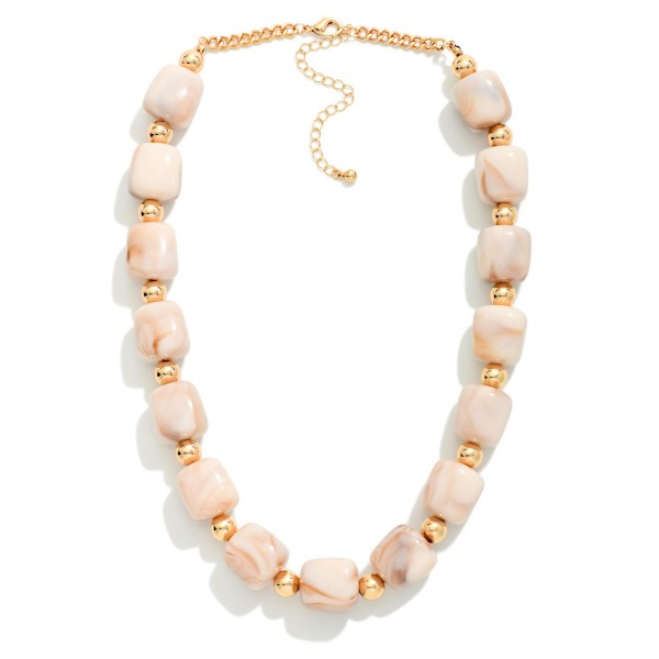 Chunky Resin Bead Necklace strung with polished barrel shaped beads spaced by small metal accents, finished with an adjustable chain extender. The marbled resin finish has the rich look of stone without the weight, so it sits comfortably at the collarbone all day. Pair it with crew neck sweaters, button downs, or simple dresses. Statement resin pieces are a strong seller for fall, and this style offers an elevated look at an easy price point.