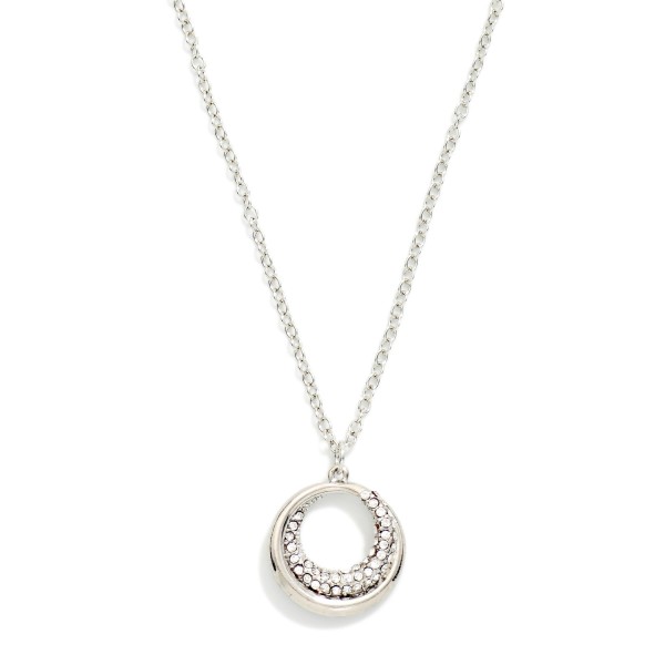 Pave Circle Pendant Necklace featuring an open ring pendant with a crescent of sparkling rhinestones. The glint of crystal adds just enough shine for everyday wear, special occasions, and holiday parties. Suspended on a fine chain with a lobster clasp and extender. A timeless circle design that makes an easy gift for birthdays, anniversaries, and bridesmaids.