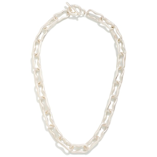 Textured Paperclip Chain Necklace with elongated links in a softly worn metal finish and a front toggle closure. The toggle becomes part of the design, giving this chain a polished, intentional look. Bold enough to wear alone and easy to layer with pendants and dainty chains. A trend right staple that turns quickly in boutiques and pairs with casual and dressy outfits alike.