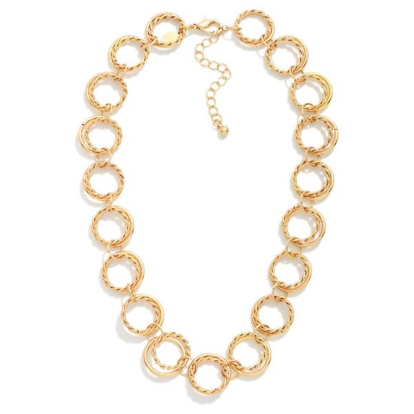Textured Circle Link Necklace made from interlocking round rings with a twisted rope texture that catches the light. The open circle design feels modern and airy while still making a confident statement at the collarbone. Finished with a lobster clasp and extender chain. A fresh alternative to classic chains that pairs easily with crew necks, V necks, and button down shirts for everyday styling.