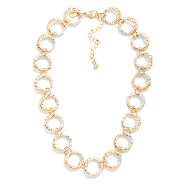 Textured Circle Link Necklace made from interlocking round rings with a twisted rope texture that catches the light. The open circle design feels modern and airy while still making a confident statement at the collarbone. Finished with a lobster clasp and extender chain. A fresh alternative to classic chains that pairs easily with crew necks, V necks, and button down shirts for everyday styling.
