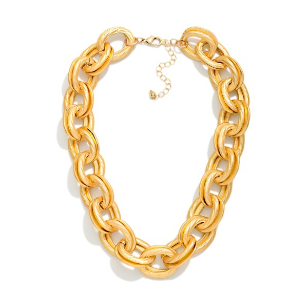 Chunky Chain Link Statement Necklace with oversized oval links in a soft matte finish. This bold collar length piece is lightweight for its size, so it makes a big impact without weighing down the neckline. Finished with a lobster clasp and extender chain. Chunky chains remain one of the most requested looks in boutiques, and this one pairs perfectly with tees, sweaters, and blazers.