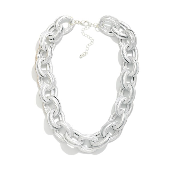 Chunky Chain Link Statement Necklace with oversized oval links in a soft matte finish. This bold collar length piece is lightweight for its size, so it makes a big impact without weighing down the neckline. Finished with a lobster clasp and extender chain. Chunky chains remain one of the most requested looks in boutiques, and this one pairs perfectly with tees, sweaters, and blazers.