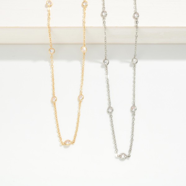 Dainty Crystal Station Necklace with tiny sparkling crystals set along a fine, delicate chain. The barely there design layers effortlessly with pendants and chokers or shines alone for a clean, minimal look. A lobster clasp and extender chain allow an adjustable fit. An everyday essential at an easy price point, perfect for bridesmaid gifts, birthdays, and customers building a layered necklace stack.
