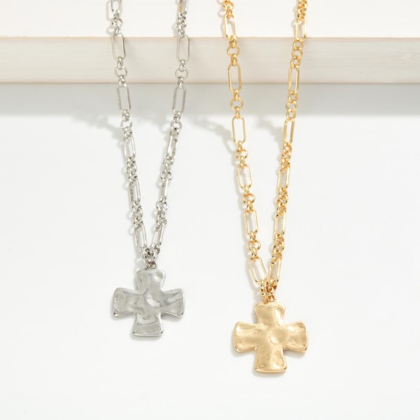 Molten Cross Pendant Necklace with a puffy, organic cross pendant that has a hand formed, melted metal look. The textured pendant hangs from a mixed link chain finished with a lobster clasp and extender for an adjustable length. A modern take on faith jewelry that works for everyday wear, Sunday services, baptisms, and Easter gifting. Cross styles sell steadily year round, and this sculptural version gives your display something fresh.