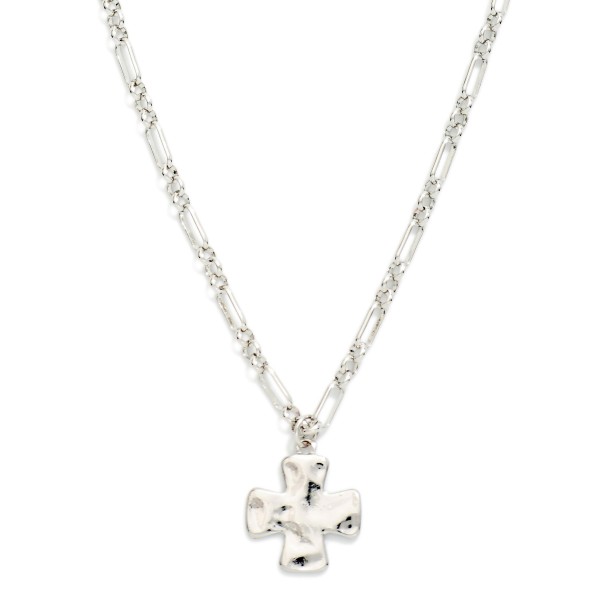 Molten Cross Pendant Necklace with a puffy, organic cross pendant that has a hand formed, melted metal look. The textured pendant hangs from a mixed link chain finished with a lobster clasp and extender for an adjustable length. A modern take on faith jewelry that works for everyday wear, Sunday services, baptisms, and Easter gifting. Cross styles sell steadily year round, and this sculptural version gives your display something fresh.