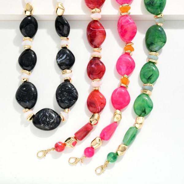 Chunky Resin Statement Necklace featuring graduated organic shaped beads with a glossy marbled finish, separated by faceted spacers and polished metal accents. Larger stones at the center create a bold focal point that elevates a plain tee, a cozy sweater, or a simple dress. Lightweight resin keeps it comfortable despite the bold scale, and an adjustable chain fits most necklines. Statement necklaces are a top add on sale, giving shoppers a quick outfit upgrade at a boutique friendly price.